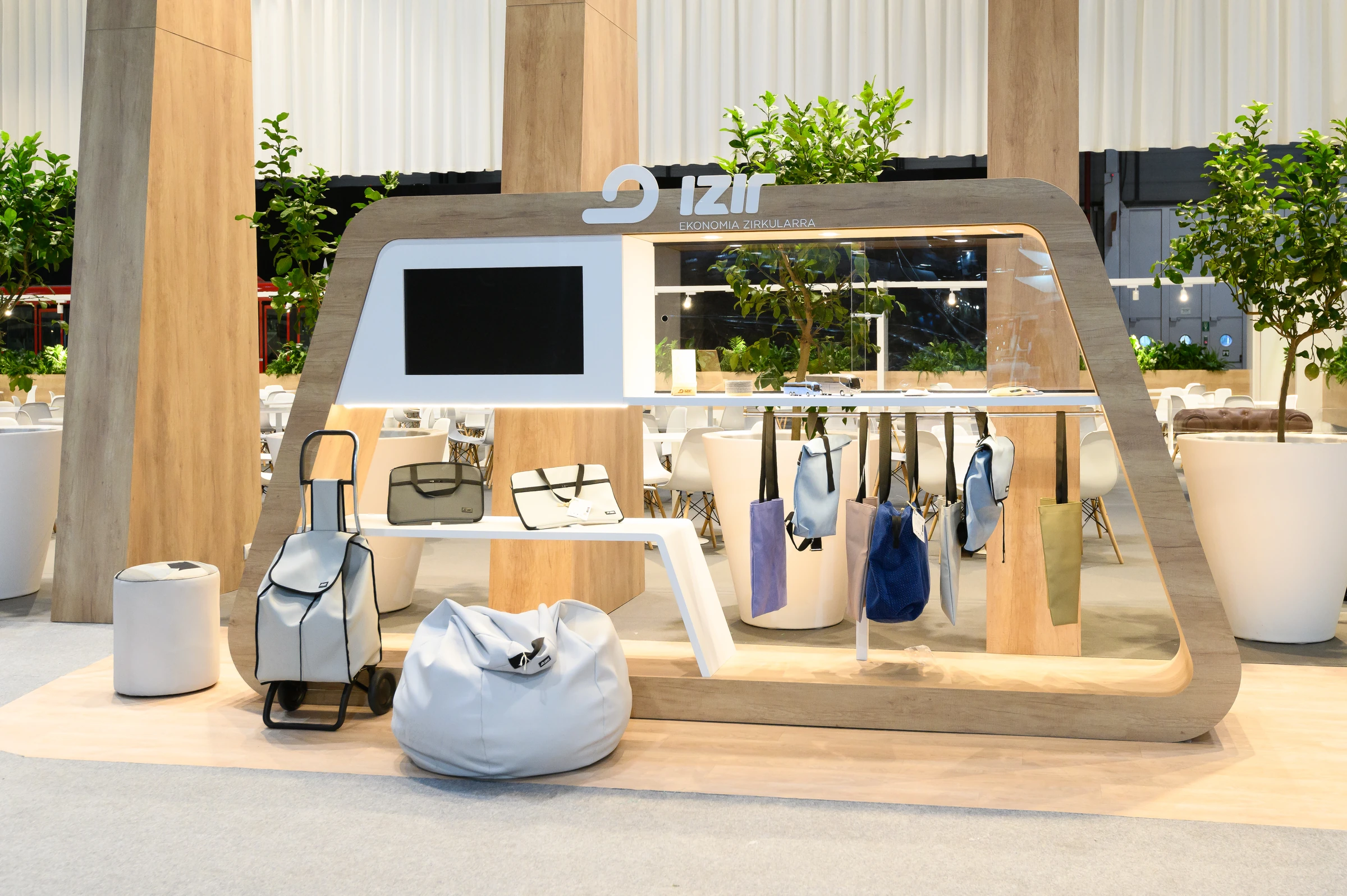 Expositor izir de madera clara, iluminación integrada y productos expuestos