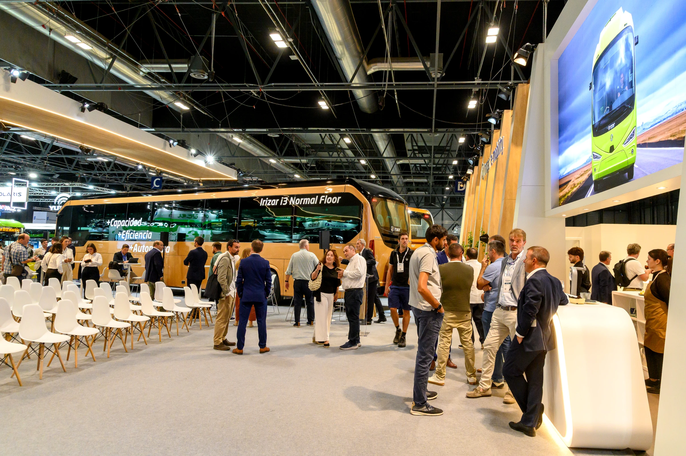 Visitantes conversando en el stand de Irizar junto a la zona social